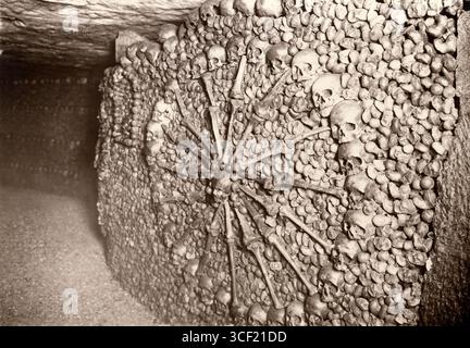 Una scultura fatta di teschi e ossa all'interno delle Catacombe di Parigi nel 1929. L'opera riflette la macabra storia del sito, che contiene milioni di resti umani. Foto Stock