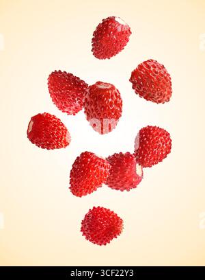 Fragole fresche mature che cadono sullo sfondo beige Foto Stock