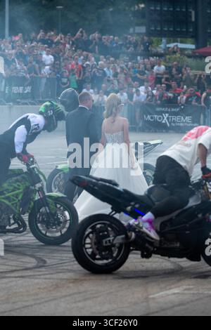 I piloti acrobatici bruciano le gomme intorno agli sposi alla festa della moto a Banja Luka, sposa e sposo in fumo Foto Stock