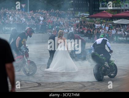 I piloti acrobatici bruciano le gomme intorno agli sposi alla festa della moto a Banja Luka, sposa e sposo in fumo Foto Stock