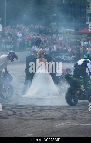 I piloti acrobatici bruciano le gomme intorno agli sposi alla festa della moto a Banja Luka, sposa e sposo in fumo Foto Stock