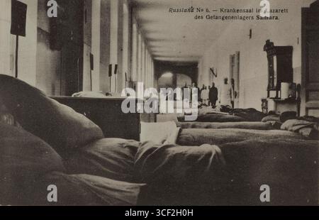 Cartolina di propaganda della prima guerra mondiale che mostra un reparto ospedaliero in un campo di prigionia, con file di letti e due pazienti visibili. La foto è stata scattata a Samara, in Russia, tra il 1914 e il 1918. Foto Stock