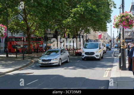 Sotto il titolo "The Future of Regent Street, Haymarket e Piccadilly Circus Public Realm", la città di Westminster e Crown Estate hanno presentato proposte per una rivisitazione delle strade, delle piazze e di altri spazi aperti della zona. Dopo un periodo di coinvolgimento delle parti interessate e del pubblico, sono previsti piani dettagliati di progetto per l'estate 2026. Il progetto masterplan propone di creare un potenziale accesso limitato ai veicoli a Pall Mall East, compreso il braccio occidentale di Trafalgar Square. Nella foto: Veicoli e pedoni a Pall Mall East. Foto Stock