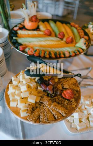 Varietà di frutta fresca e formaggi esposti magnificamente a un raduno festivo Foto Stock