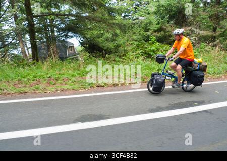 Uomo a cavallo di un pieno carico delle biciclette da turismo sulla Scenic Otter Crest Loop, Lincoln County, Oregon, Stati Uniti d'America Foto Stock