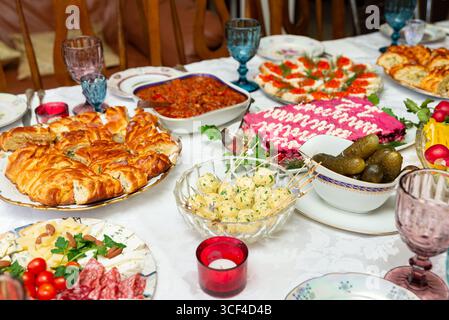 Un tavolo splendidamente organizzato con una gamma di antipasti e piatti, perfetto per una riunione di festa. la vivace varietà comprende insalate e pastrie Foto Stock