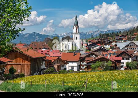 Bad Hindelang con la chiesa parrocchiale cattolica di St. Johannes Baptist Foto Stock