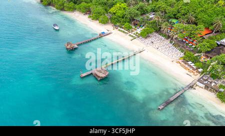 Splendida vista aerea della spiaggia delle Isole Rosario con acque cristalline, moli di legno e vegetazione lussureggiante a Cartagena, Colombia. Foto Stock