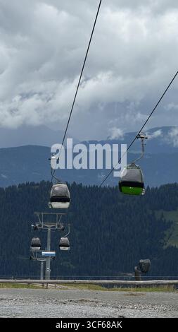 Le funivie di montagna scivolano attraverso le panoramiche colline boscose. L'immagine cattura la vista serena e maestosa di montagne e funivie che si muovono senza intoppi al mattino Foto Stock
