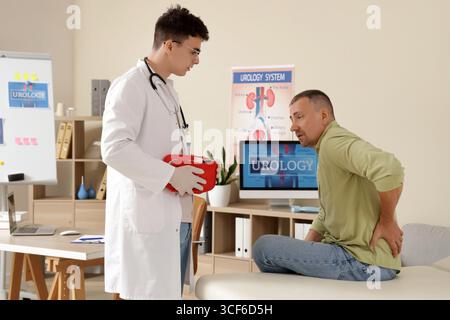 Giovane urologo con kit di pronto soccorso e uomo maturo in clinica Foto Stock