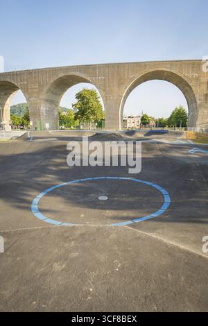 Pista pompa con strisce blu distintive di fronte a un viadotto con archi, pista pompa Nagold, quartiere Calw, Germania Foto Stock
