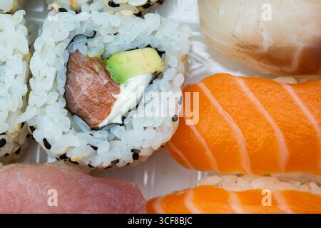 Assortimento di sushi di prima qualità con nigiri di salmone, involtini di avocado e guarnizione allo zenzero. Perfetto per menu di ristoranti, blog culinari, cucina giapponese Foto Stock