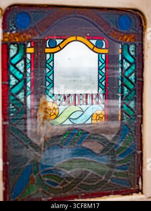 Una vetrata con il nome di "Saltburn" in una carrozza vittoriana ornata della Saltburn Cliff Tramway, North Yorkshire, Regno Unito. Foto Stock