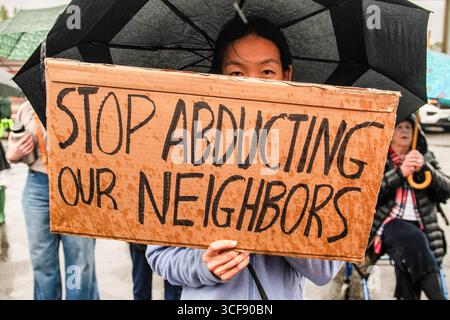 Danbury, Stati Uniti. 20 agosto 2025. Un sostenitore della comunità di migranti ha un cartello con scritto "SMETTI DI RAPIRE I NOSTRI VICINI" durante un briefing stampa tenuto in un parcheggio di fronte alla corte superiore. Un briefing stampa e protesta sono stati tenuti contro le incursioni locali di I.C.E. che hanno portato alla detenzione di più persone migranti. Gli individui sono stati arrestati mentre andavano al lavoro. Credito: SOPA Images Limited/Alamy Live News Foto Stock