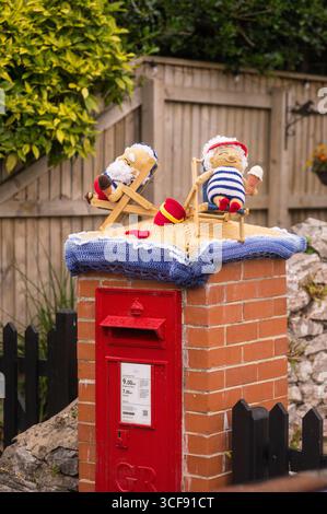Miniature di lana reclinabili su sdraio in una cassetta per posta a Weston super Mare, Somerset, Inghilterra Foto Stock