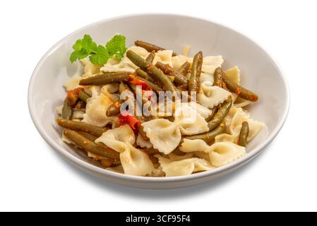 Pasta con cravatta con fagioli verdi e salsa di pomodoro, guarnita con un rametto di menta, su un piatto bianco isolato su bianco con percorso di ritaglio incluso Foto Stock