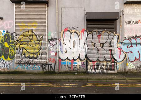 Manchester, regno unito, 19 gennaio 2025 Una vivace parete urbana ricoperta di graffiti che mostra espressioni artistiche, tag e disegni colorati in un ambiente urbano. Foto Stock