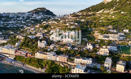 Vista mozzafiato sulla costa del tranquillo villaggio collinare immerso nella vegetazione lussureggiante al tramonto Foto Stock