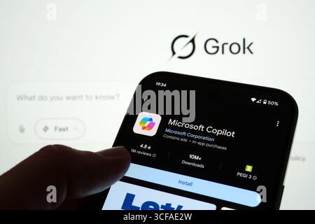 Telefono Android su Google Play che mostra l'elenco dell'app Microsoft Copilot con il marchio Grok sullo sfondo. Stafford, Regno Unito, 21 agosto 2025 Foto Stock