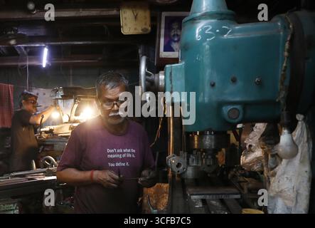 Kolkata, Bengala Occidentale, India. 21 agosto 2025. Il 21 agosto 2025 un lavoratore gestisce una macchina per realizzare diverse parti di macchinari all'interno di uno stabilimento di produzione a Kolkata, India. (Immagine di credito: © Rupak De Chowdhuri/ZUMA Press Wire) SOLO PER USO EDITORIALE! Non per USO commerciale! Foto Stock