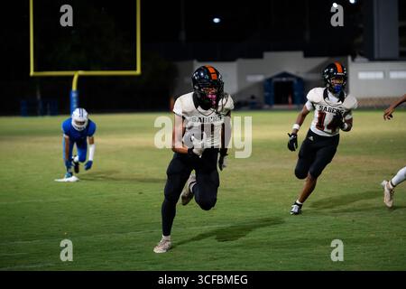 Il wide receiver Shaison Kupuka'a della Campbell High School supera i difensori dopo il cath e segna un touchdown contro la Moanalua High School Foto Stock