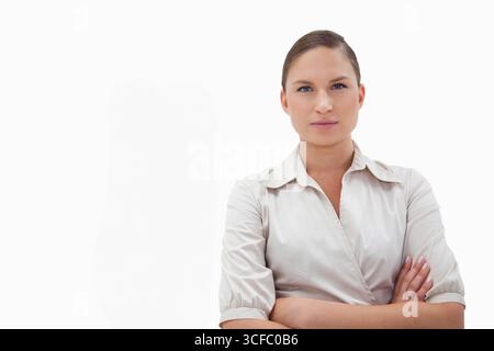 Donna in piedi con le braccia incrociate nello studio fotografico che indossa una camicetta con colletto, copia spazio Foto Stock