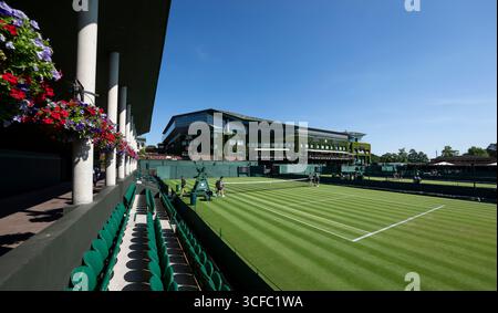 Giudici sul Tribunale 8 con il Tribunale centrale sullo sfondo davanti ai Campionati 2025. Si tiene all'All England Lawn Tennis Club di Wimbledon. Foto Stock
