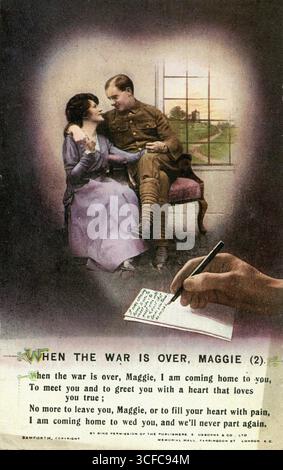 Un'antica cartolina prodotta dalla Bamforth & Co Ltd durante la prima guerra mondiale come souvenir per i soldati che prestano servizio sul fronte occidentale. La carta raffigura una mano che scrive una lettera e all'interno di una vignetta a forma di cuore, un soldato siede accanto alla sua fidanzata, tenendo la mano e il braccio intorno alla spalla. Di seguito è riportato un verso della canzone popolare, "quando la guerra è finita, Maggie". Foto Stock