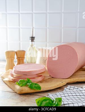 salsiccia bollita su un tavolo di legno con erbe aromatiche Foto Stock