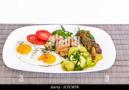 Colazione con dieta chetogenica. Carne arrosto con uova al sole, verdure e insalata. Cibo sano, cheto, dieta paleo, concetto di pranzo dietetico. Vista superiore, Copia Foto Stock