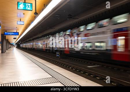 Zurigo, Svizzera, 19 agosto 2025. Confuso, treno passeggeri in movimento in partenza e persone in attesa all'interno della piattaforma della stazione principale della metropolitana Foto Stock