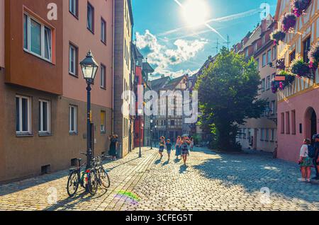 Norimberga, Germania, 14 luglio 2024: Persone che camminano lungo la strada pedonale acciottolata, edifici e luci medievali, turisti passeggiano nel centro storico di Norimberga Foto Stock