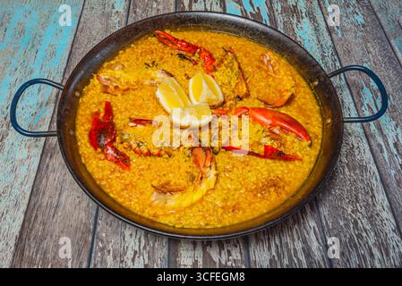 Paella di aragosta con crostacei interi come contorno, servita direttamente dalla padella alla tavola Foto Stock