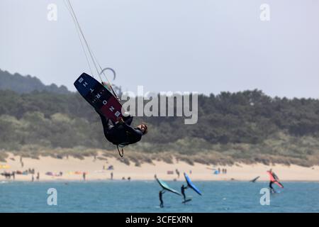 Cabedelo, Viana do Castelo, Portogallo - 21 agosto 2025: Kitesurf sull'Oceano Atlantico con tavole da surf che saltano sopra le onde Foto Stock
