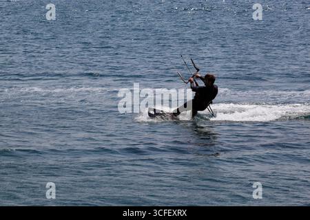 Cabedelo, Viana do Castelo, Portogallo - 21 agosto 2025: Kitesurf sull'Oceano Atlantico con tavole da surf che saltano sopra le onde Foto Stock
