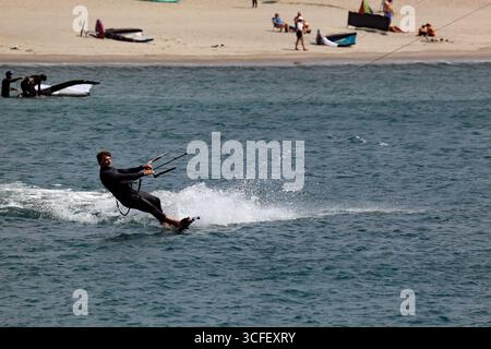 Cabedelo, Viana do Castelo, Portogallo - 21 agosto 2025: Kitesurf sull'Oceano Atlantico con tavole da surf che saltano sopra le onde Foto Stock