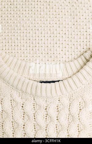 Primo piano di un comodo pullover bianco in maglia a cavo con scollo a coste e tasca Foto Stock