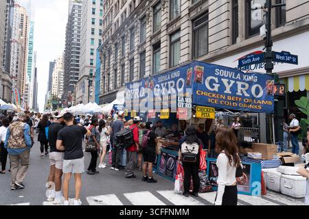 La gente gode di una fiera del cibo e dell'artigianato lungo la 6th Avenue tra la 34th e la 42nd Street di Manhattan. Foto Stock