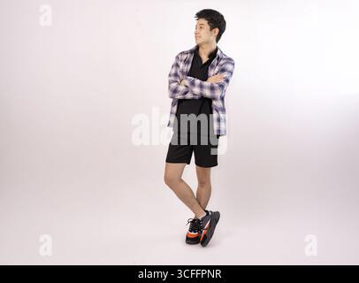 giovane uomo informale che posa con sicurezza in un abbigliamento moderno su sfondo bianco Foto Stock