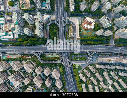 La vista dall'alto verso il basso di un incrocio affollato rivela una moltitudine di veicoli che viaggiano su varie carreggiate. Hangzhou, Cina. Foto Stock