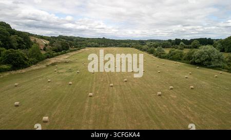Veduta aerea dei terreni agricoli con balle di fieno rotonde dopo il raccolto nella campagna del Worcestershire, Inghilterra - paesaggio rurale agricolo britannico Foto Stock