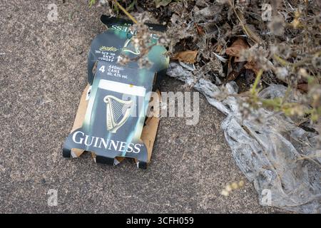 MARSH BARTON, EXETER, DEVON, Regno Unito - 24 SETTEMBRE 2024 rifiuti gettati sul bordo laterale della strada di marciapiede - involucro di carta Guinness Foto Stock