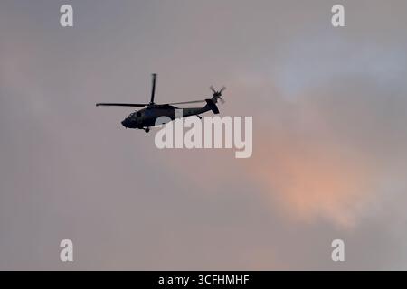 Israele Air Force Sikorsky S-70A Yanshuf UH-60 Black Hawk elicotteri in volo, equipaggiamento giù, contro nuvole crepuscolari che mostrano colori tenui e foschia. Foto Stock