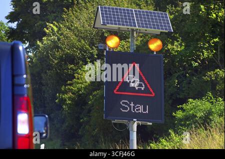 Segnaletica stradale con avviso di ingorgo alimentato a energia solare sull'autostrada Baden-Wuerttemberg, Germania Foto Stock
