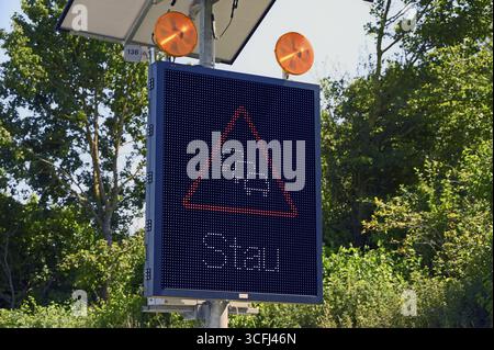 Segnaletica stradale con avviso di ingorgo alimentato a energia solare sull'autostrada Baden-Wuerttemberg, Germania Foto Stock