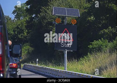 Segnaletica stradale con avviso di ingorgo alimentato a energia solare sull'autostrada Baden-Wuerttemberg, Germania Foto Stock