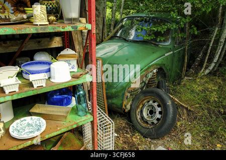 Offerta presso un Loppis, un mercato delle pulci svedese, porcellana e un Maggiolino VW distrutto, Vaermland, Svezia Foto Stock