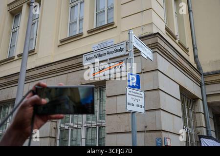 Ein Besucher fotografiert mit seinem Mobiltelefon das neue Strassenschild waehrend des Strassenfests am Hausvogteiplatz a Berlin zur offiziellen Umbenennung der Mohrenstrasse a Berlin-Mitte in Anton-Wilhelm-amo-Strasse foto vom 23.08.2025. Bis zum Schluss wurde mit juristischen Mitteln um die Umbenennung gestritten. Seit dem spaeten Freitagabend 22.08.2025 ist klar: Berlin Hat kuenftig eine Anton-Wilhelm-amo-Strasse, benannt nach dem ersten bekannten Philosophen afrikanischer Herkunft in Deutschland. Der neue Strassenname wurde bei dem Strassenfest wiederholt mit grossem Applaus Bedacht. Rosso Foto Stock