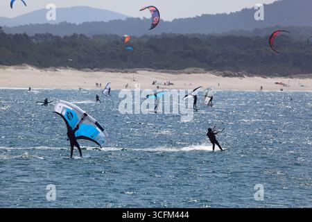 Cabedelo, Viana do Castelo, Portogallo - 21 agosto 2025: Varietà di attività di surf sulla spiaggia dell'Oceano Atlantico, kitesurf, windsurf Foto Stock
