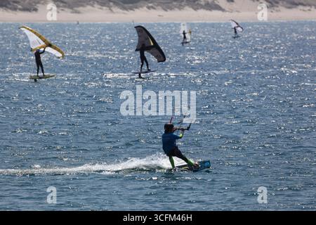 Cabedelo, Viana do Castelo, Portogallo - 21 agosto 2025: Varietà di attività di surf sulla spiaggia dell'Oceano Atlantico, kitesurf, windsurf Foto Stock